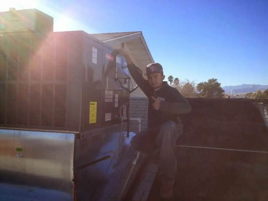 HVAC technician performing Heat Pump Repair on a rooftop unit in Purcell